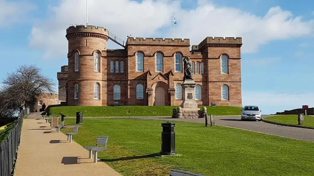 a large brick building with a statue in front of it at Riverside View in Inverness