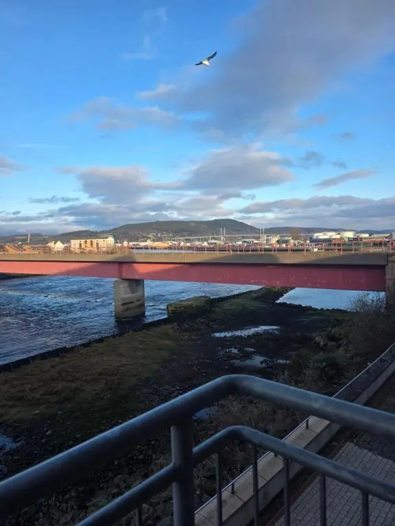 a bridge over a river with a train on it at Riverside View in Inverness
