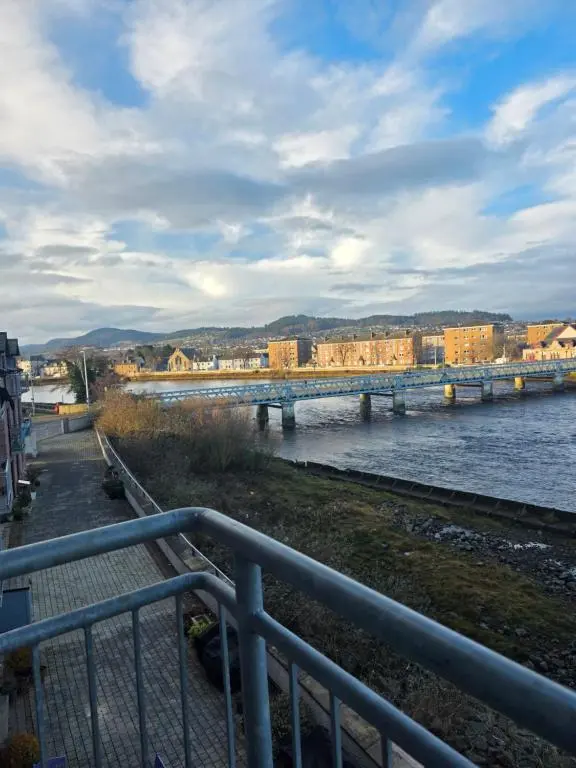 a bridge over a river with buildings in the background at Riverside View in Inverness
