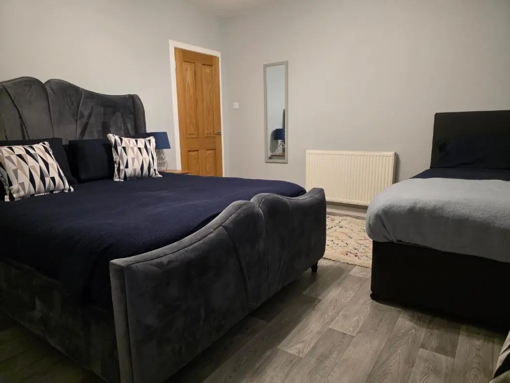a bedroom with a couch next to a bed at 14 Harbour View in Wick