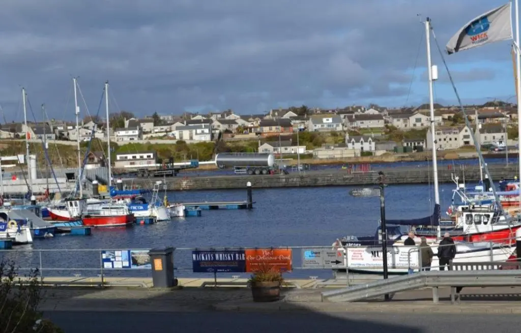 a marina with boats in the water and a town at 14 Harbour View in Wick