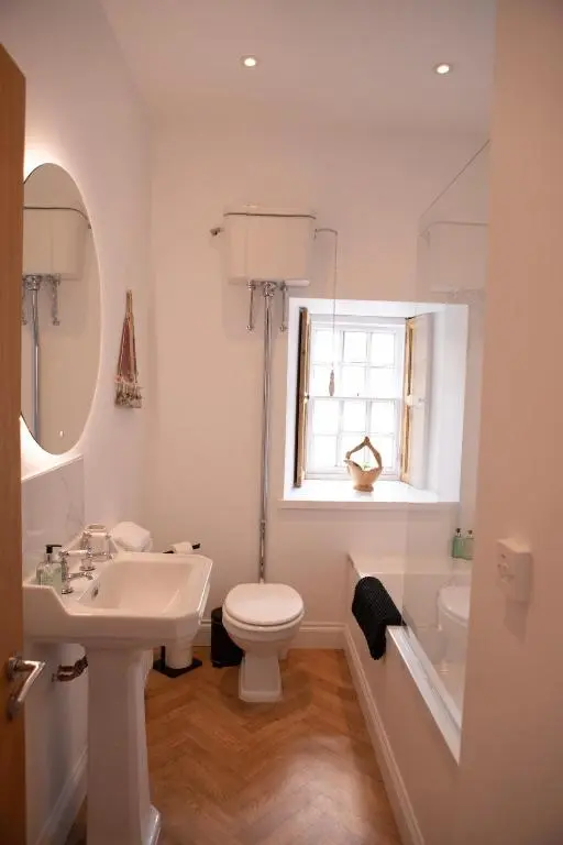 a bathroom with a sink and a toilet and a window at Calder House, Fochabers in Fochabers