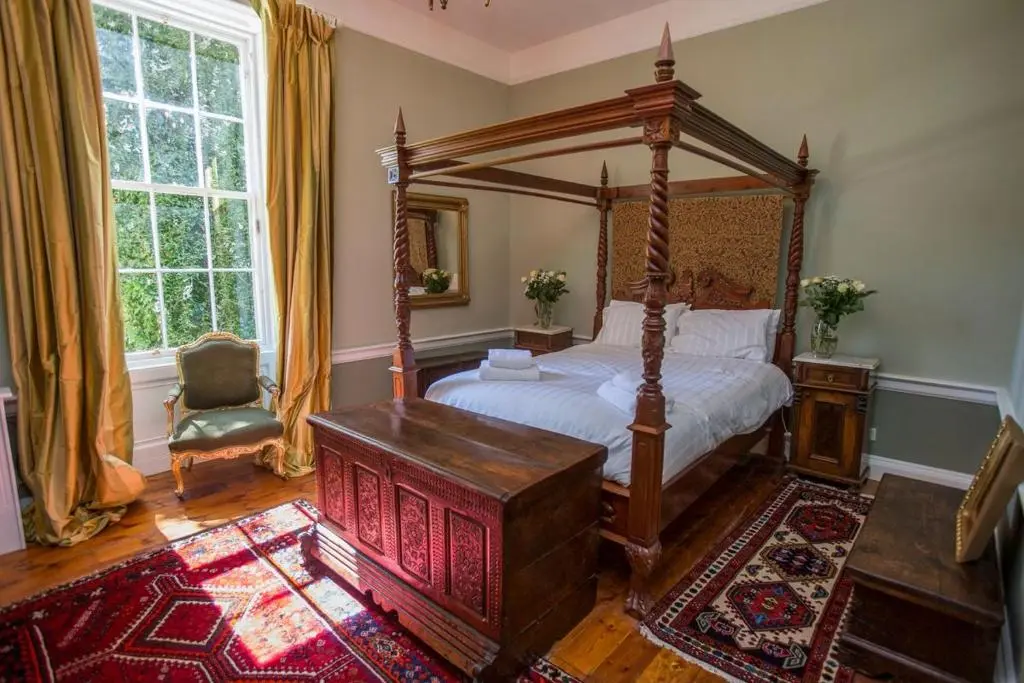 a bedroom with a canopy bed and a chair at Averon Castle in Alness
