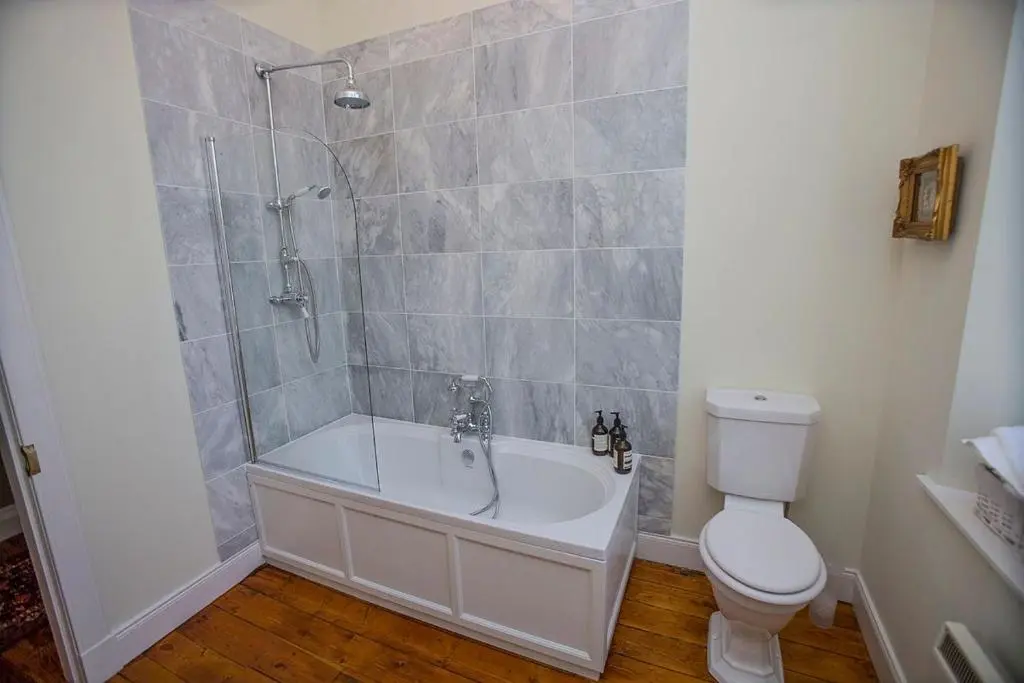 a bathroom with a shower and a tub and a toilet at Averon Castle in Alness