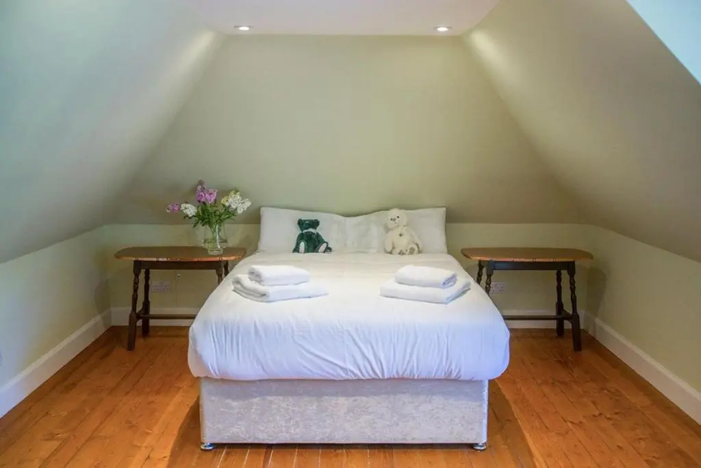 a bedroom with a white bed with two tables at Averon Castle in Alness