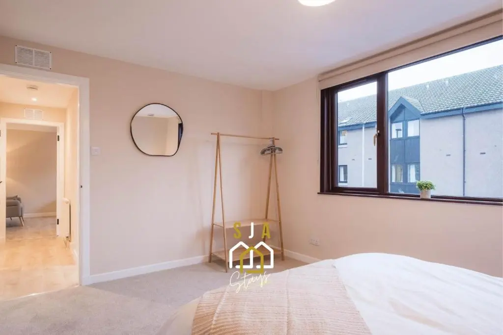 a bedroom with a bed and a large window at Fraserburgh Stay - SJA Stays - Modern 2 Bed Apartment in Fraserburgh