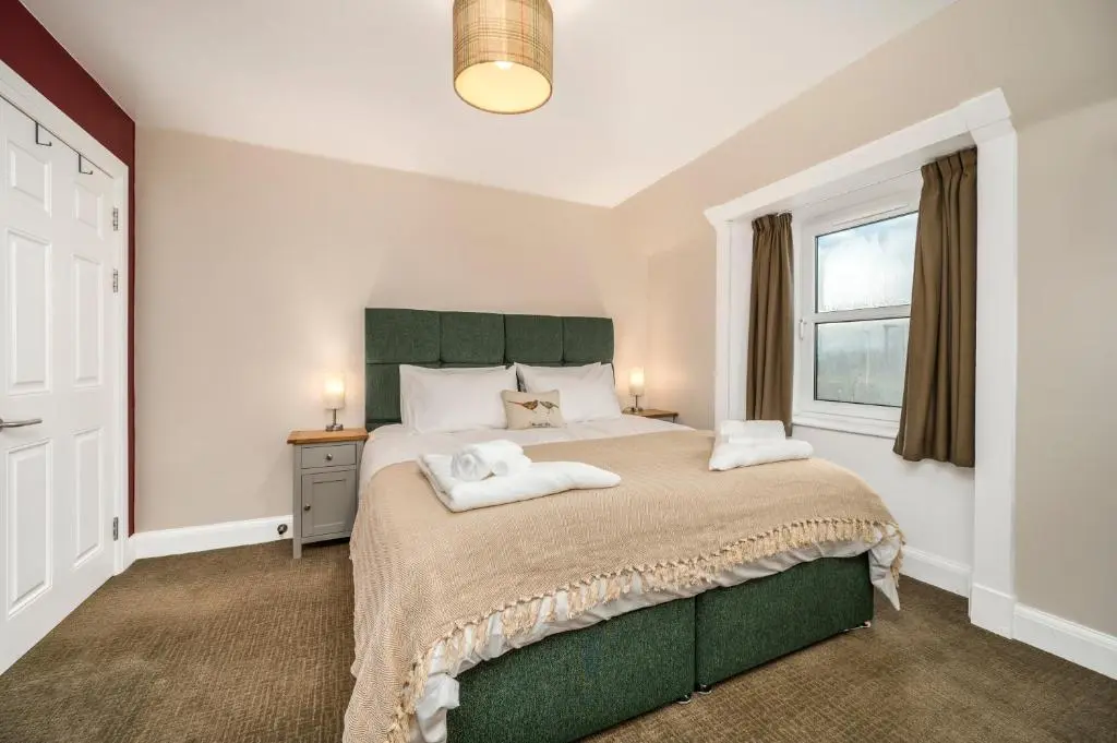 a bedroom with a large bed and a window at Burnside, Dornoch in Dornoch