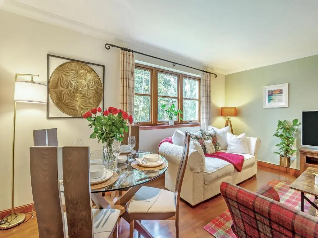 a living room with a table and a couch at Cosy Ness in Inverness
