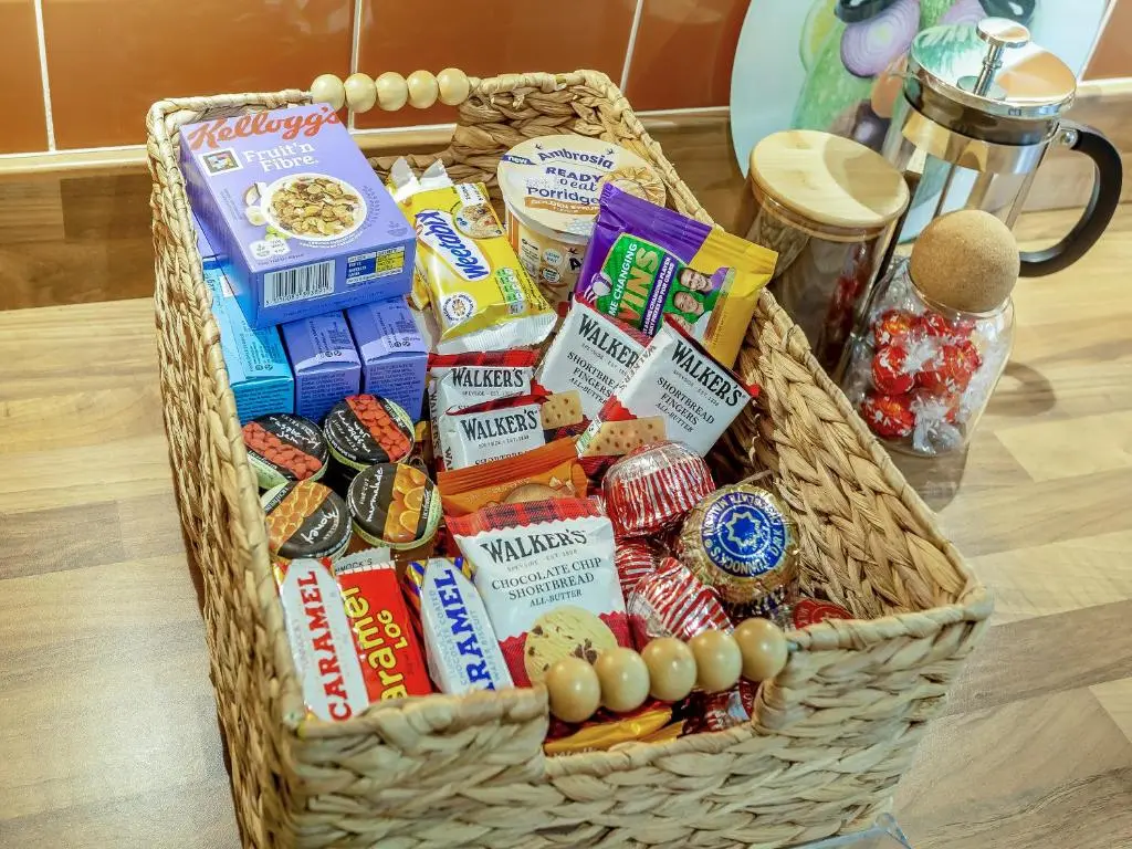 a basket full of food and snacks on a table at Cosy Ness in Inverness