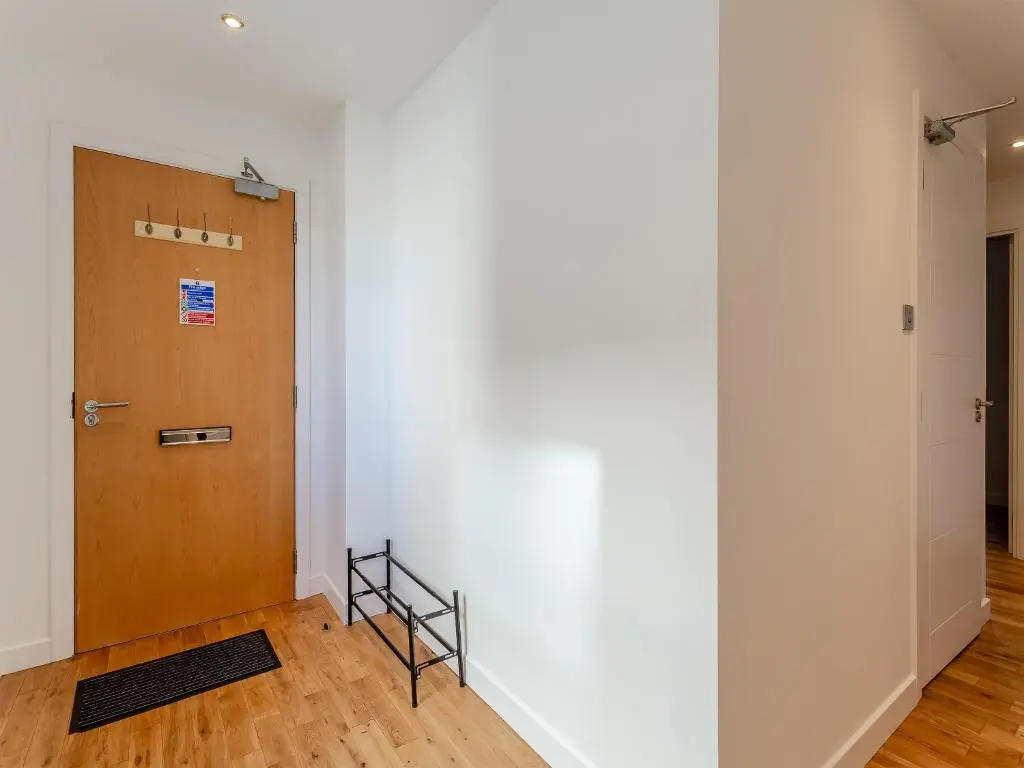a hallway with a door and a rug next to it at Inverness Highland Apartment in Inverness
