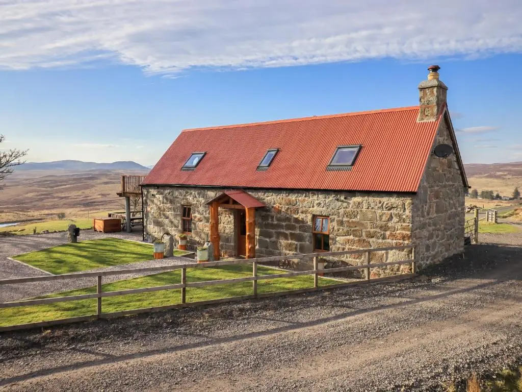 an old stone barn with a red roof at Kestrel Cottage in Rogart