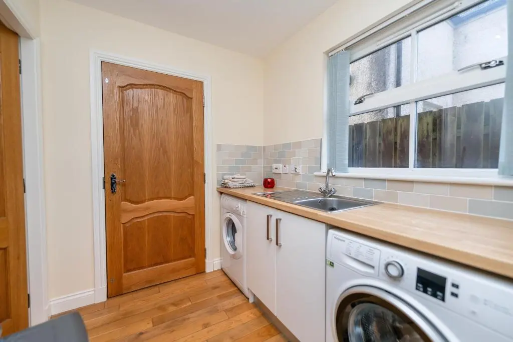 a kitchen with a sink and a washing machine at Abbey View in Old Deer