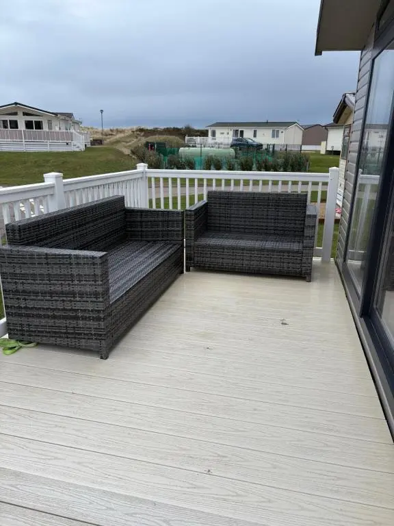 a patio with two couches on a deck at Sunset villa in Lossiemouth