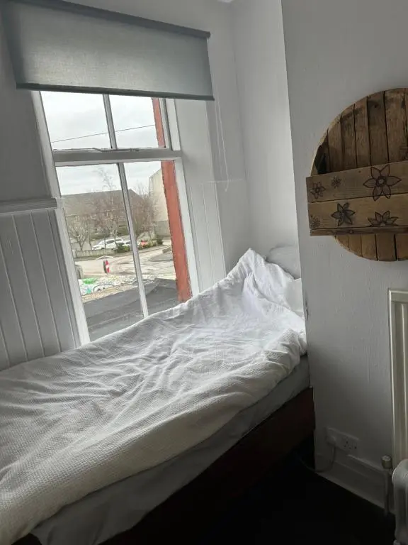 a bed in a room with a window at The Staging Post in Aberdeen