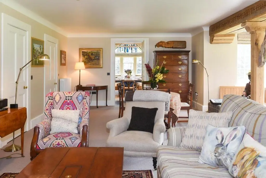 a living room with a couch and chairs and a table at Spey Valley House in Ruthven