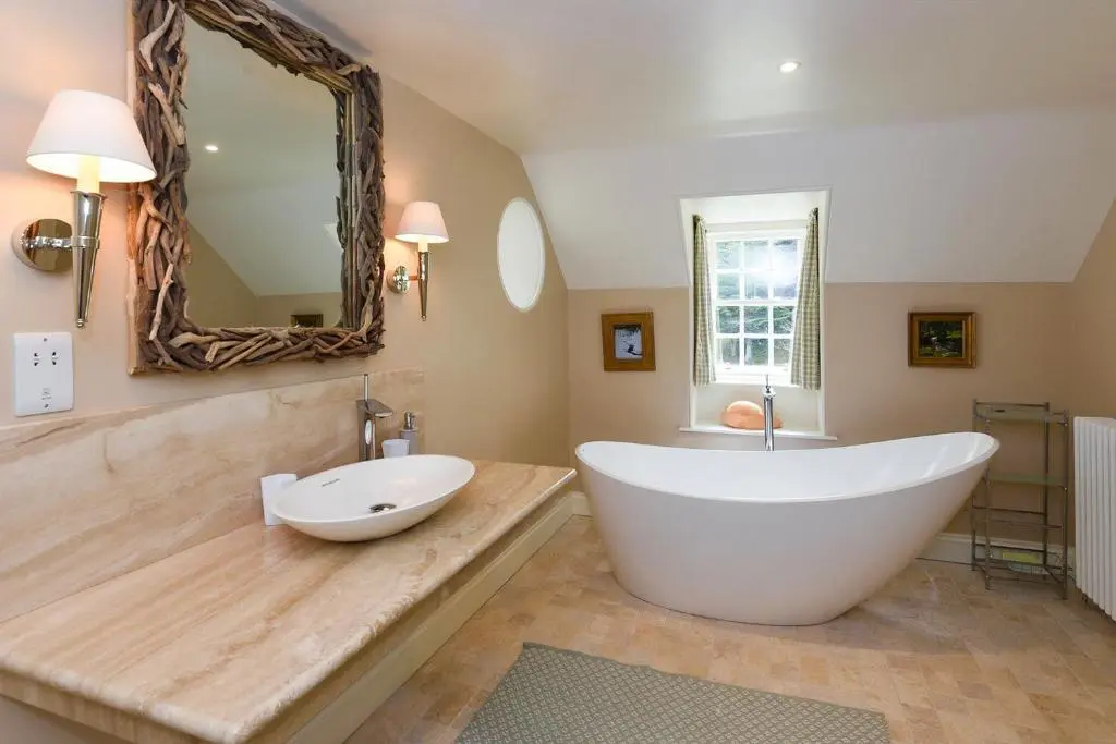 a large bathroom with a large tub and a sink at Spey Valley House in Ruthven