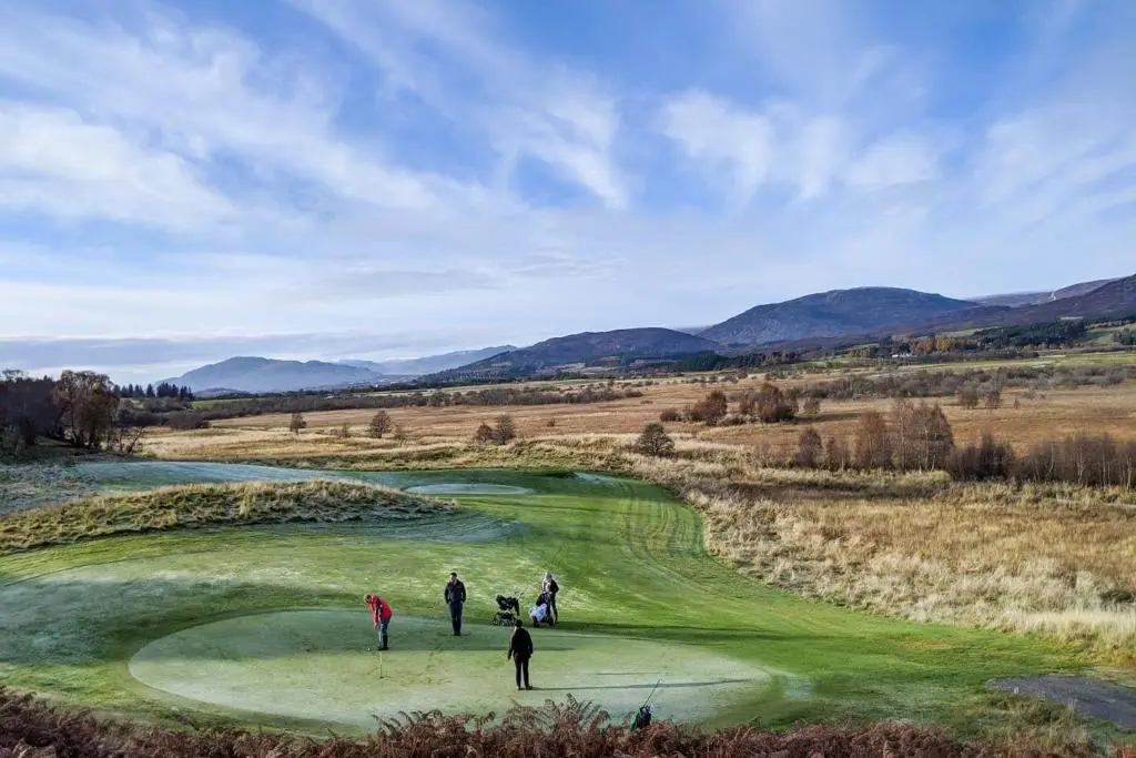 a group of people standing on a golf course at Spey Valley House in Ruthven