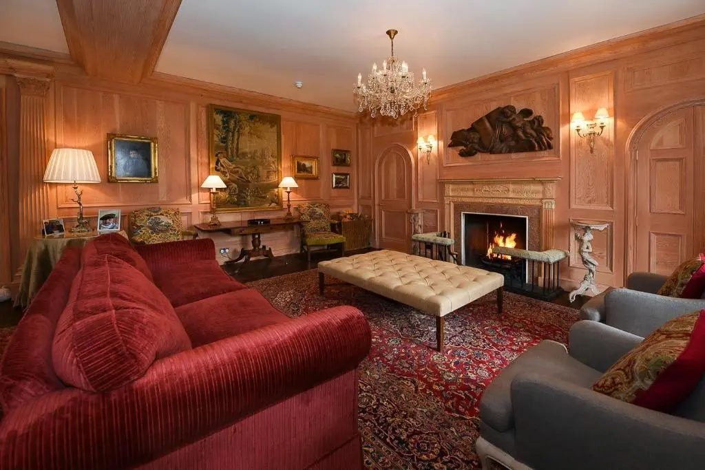 a living room with a red couch and a fireplace at Spey Valley House in Ruthven