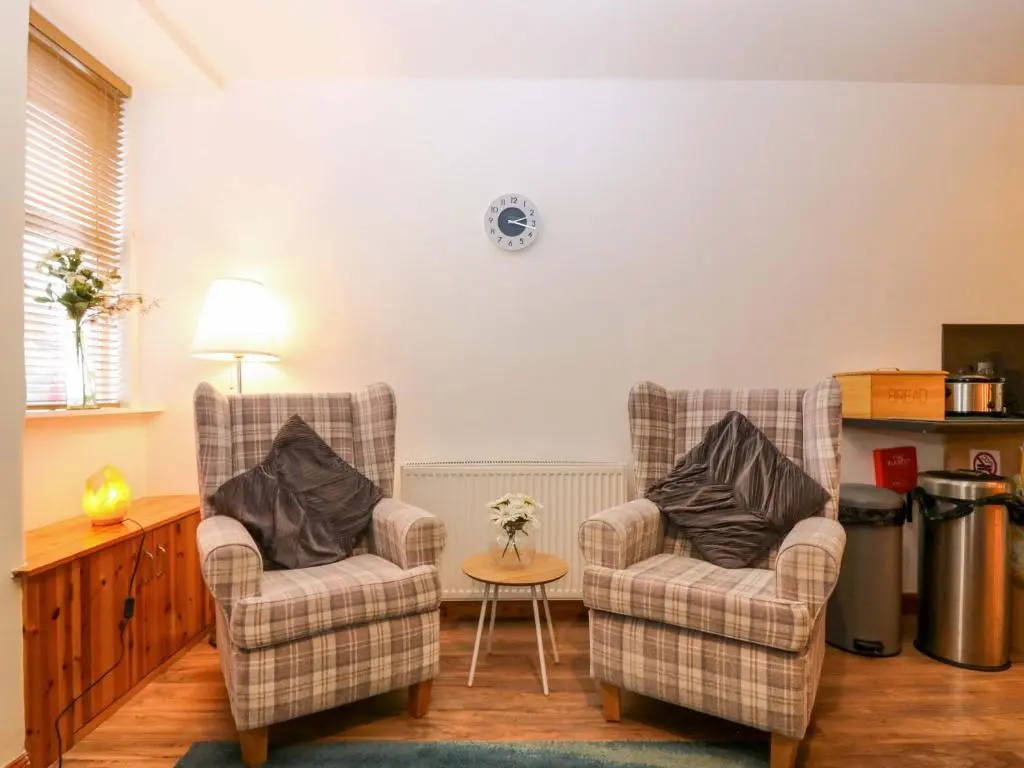 two chairs and a table in a living room at Rose Cottage in Nairn