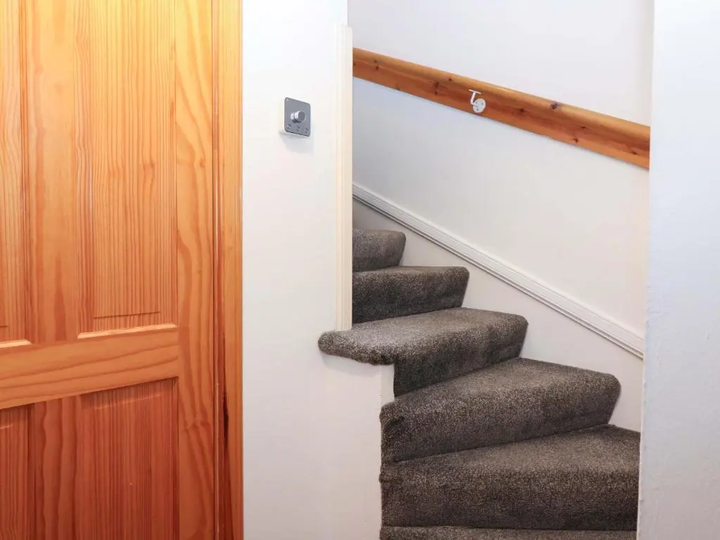 a set of stairs in a house with a door at Rose Cottage in Nairn