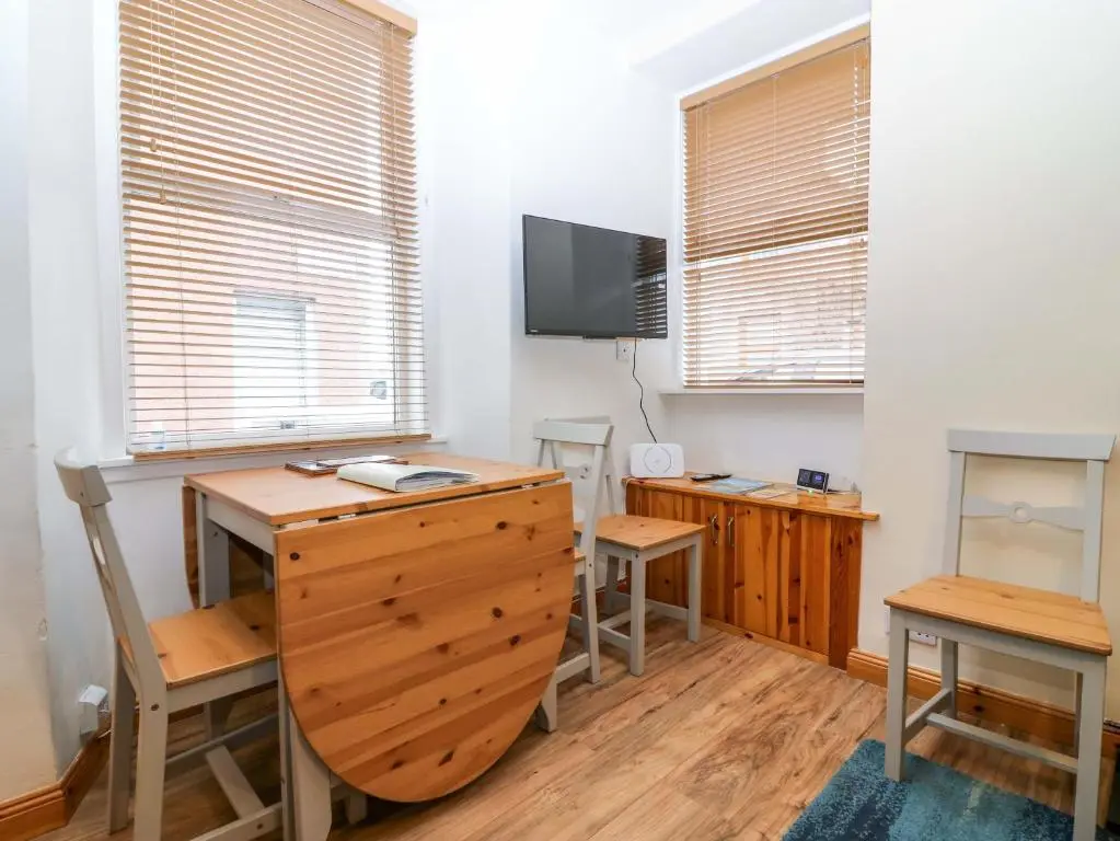 a home office with a desk and a tv at Rose Cottage in Nairn