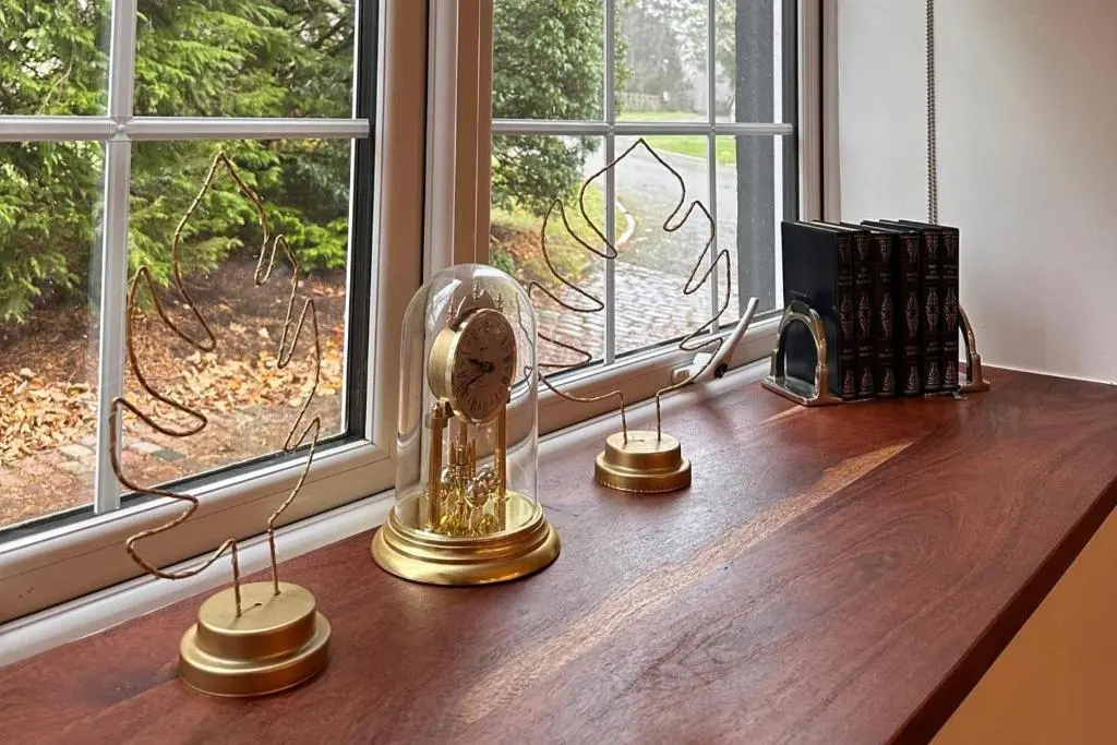 a clock on a wooden table next to a window at Pets - Garden - Parking - Sleeps 2 - Hiking in Banchory