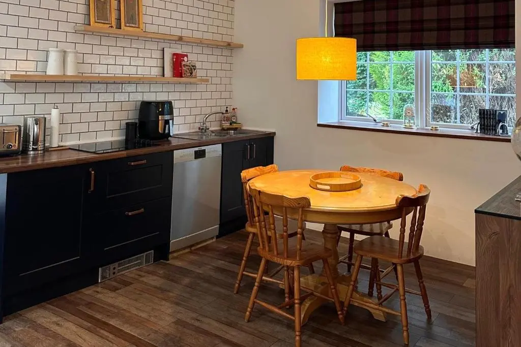 a kitchen with a wooden table and a table and chairs at Pets - Garden - Parking - Sleeps 2 - Hiking in Banchory