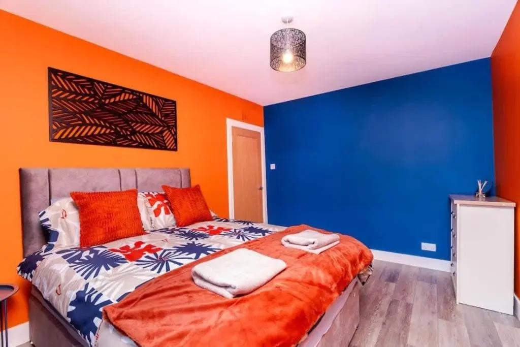 a bedroom with blue and orange walls and a bed at Aberdeen Airport Cozy Apartment - 3 Beds - Sleeps 5 with Free Parking and Fast Wi-Fi in Aberdeen
