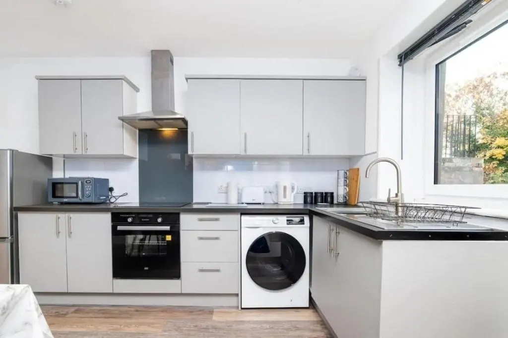 a kitchen with white cabinets and a dishwasher at Aberdeen Airport Cozy Apartment - 3 Beds - Sleeps 5 with Free Parking and Fast Wi-Fi in Aberdeen