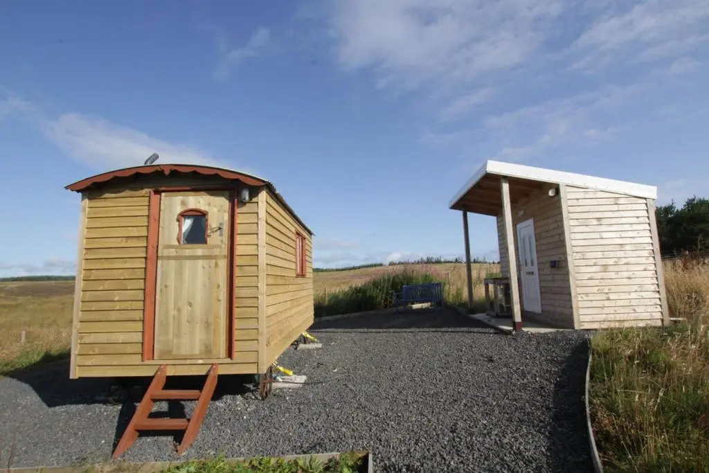 a wooden out house next to a smallshed at The Rumster Hut in Lybster