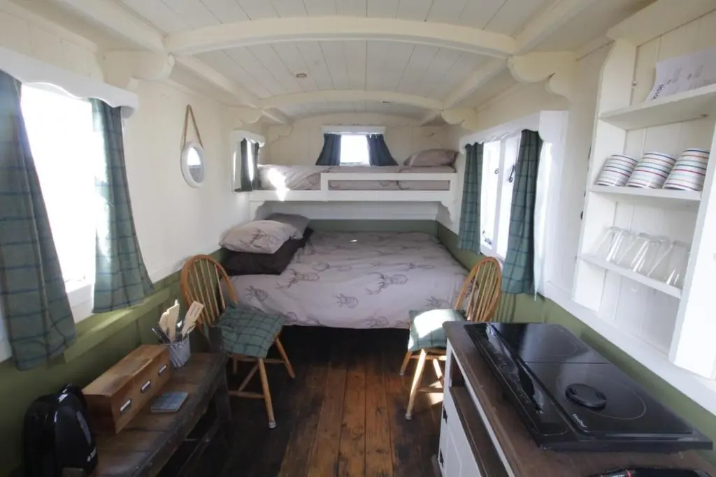 a small room with a bed and two chairs in it at The Rumster Hut in Lybster