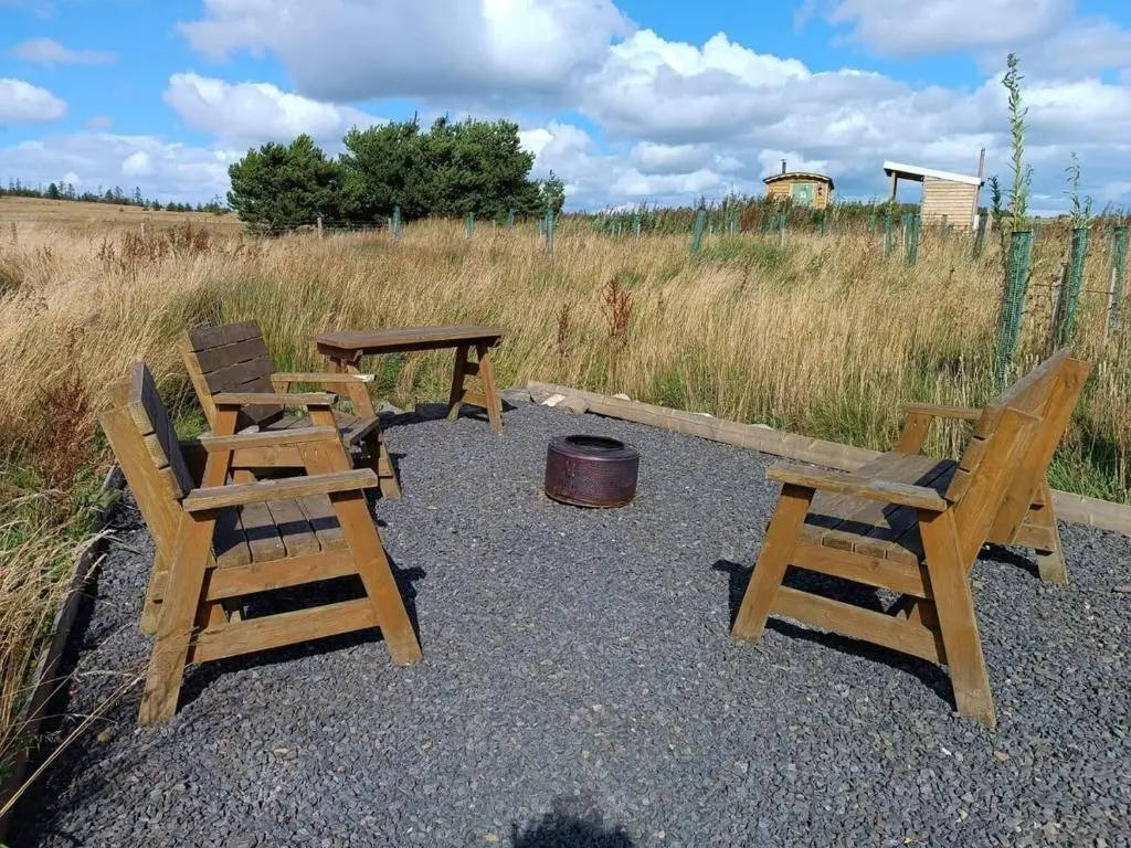 a group of chairs and a picnic table and a barrel at The Rumster Hut in Lybster