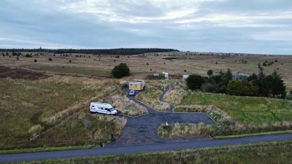 a white van parked on a road in a field at The Rumster Hut in Lybster