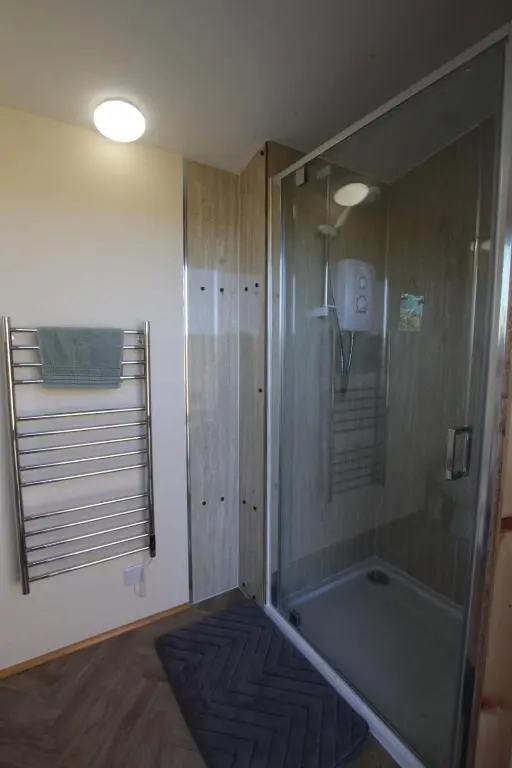 a bathroom with a shower and a bath tub at The Rumster Hut in Lybster