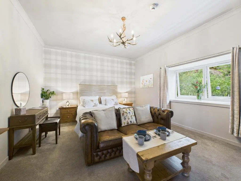 a living room with a couch and a bed at Glenshee Suite, Beechtree Cottage in Kirkmichael