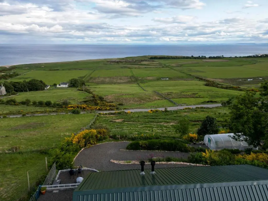 two people standing on top of a building in a field at Lothmore Lookout - Sunset in Kilmote