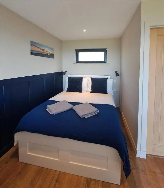 a bedroom with a large bed with two towels on it at Lothmore Lookout - Sunset in Kilmote