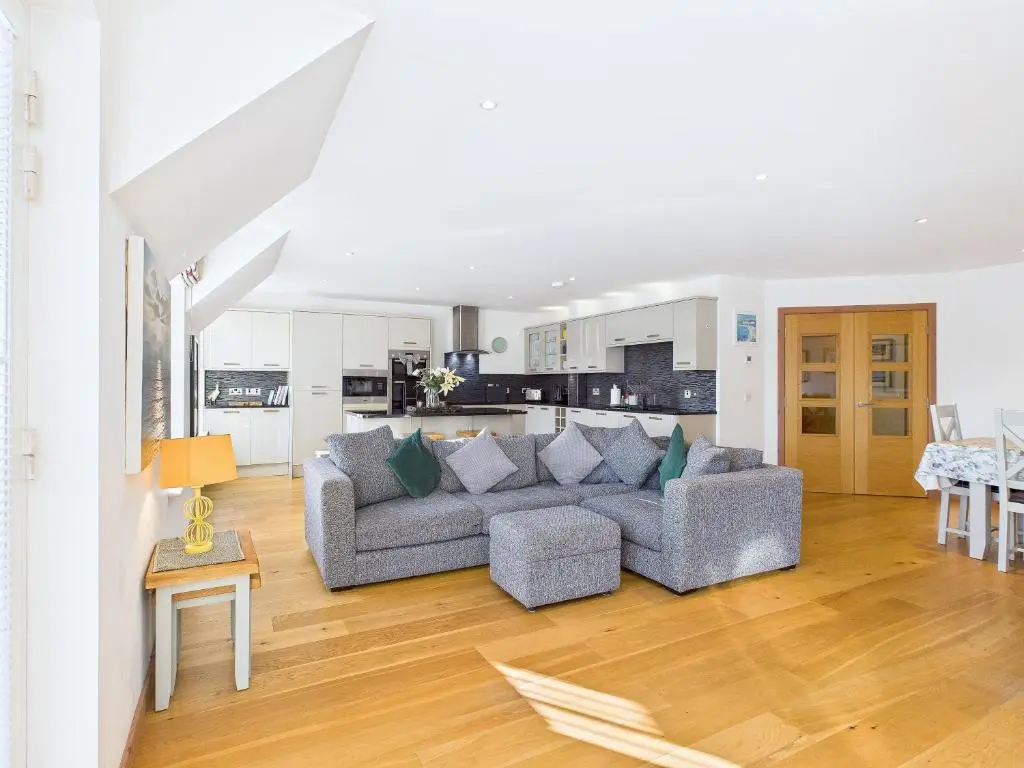 a living room with a couch and a kitchen at The Steadings Aviemore Premium Highland Apartment Near Cairngorms & Town Centre in Aviemore