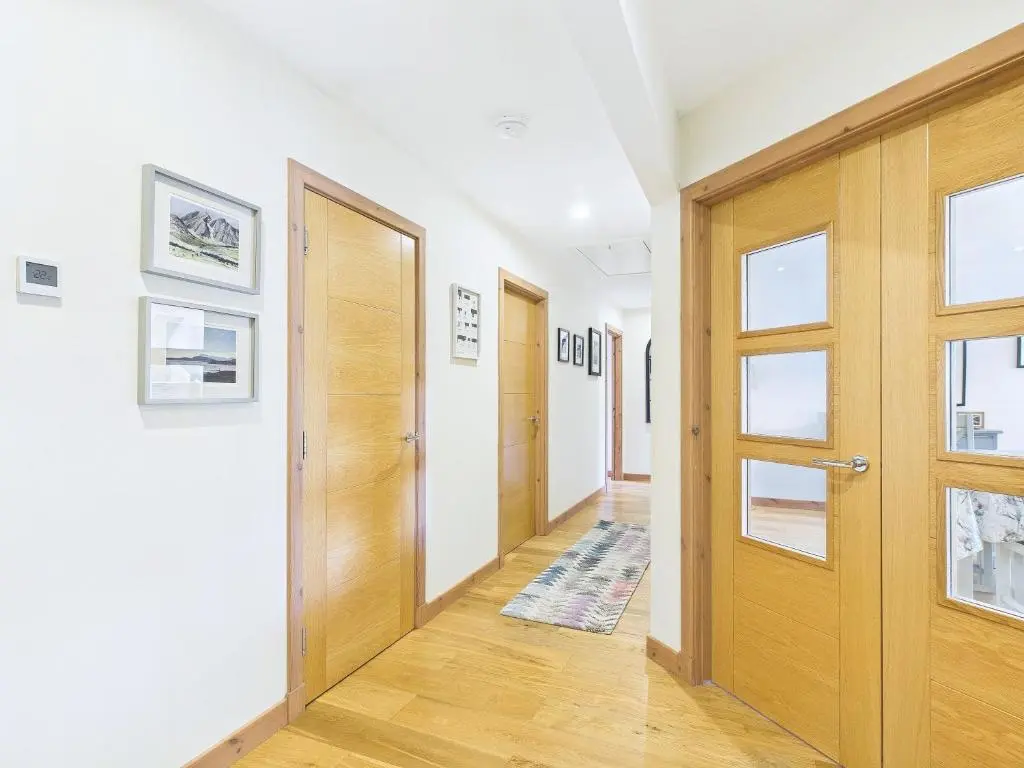 a hallway with a wooden door in a house at The Steadings Aviemore Premium Highland Apartment Near Cairngorms & Town Centre in Aviemore