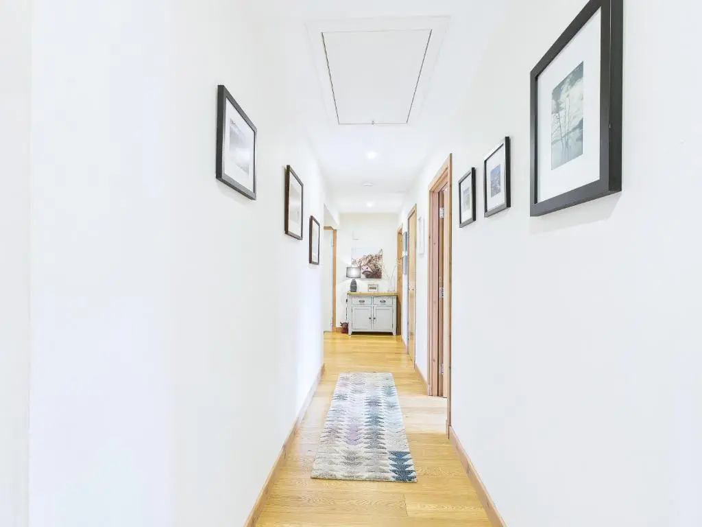 a hallway with a row of pictures on the walls at The Steadings Aviemore Premium Highland Apartment Near Cairngorms & Town Centre in Aviemore