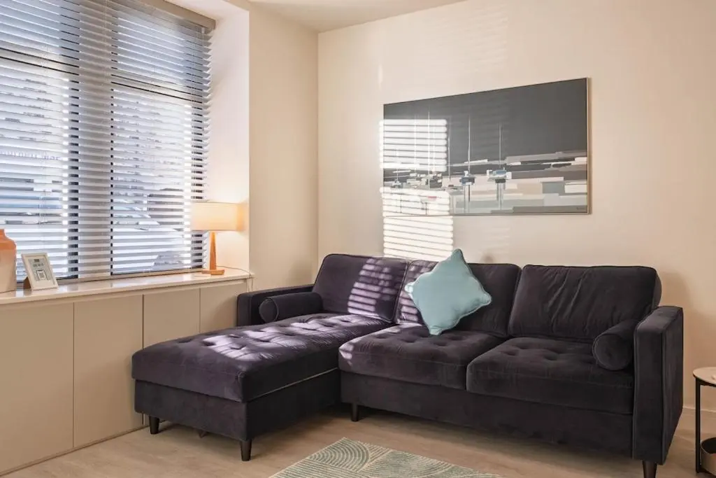 a living room with a brown couch and a table at Modern Central Apartment Huntly in Huntly