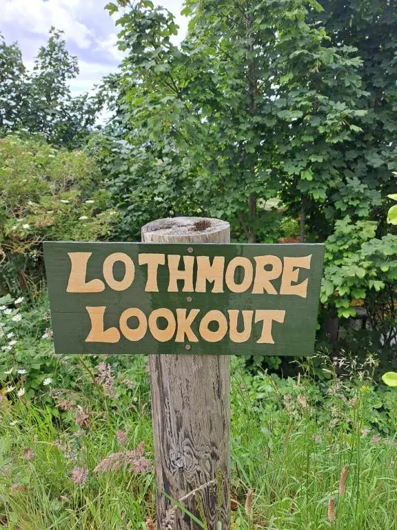 a sign on a wooden post in a garden at Lothmore Lookout - Sunrise in Kilmote
