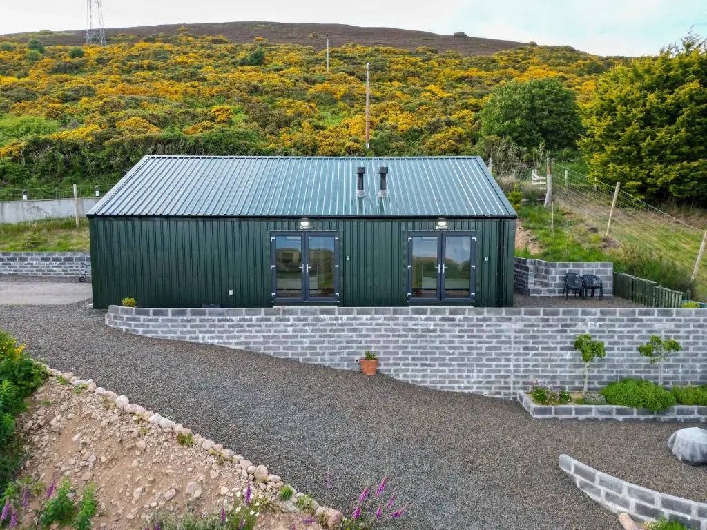a green house with a brick retaining wall at Lothmore Lookout - Sunrise in Kilmote