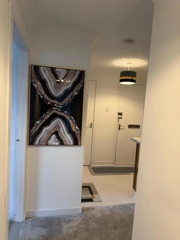 a hallway with a painting on the wall at Nessy5 Apartment in Inverness
