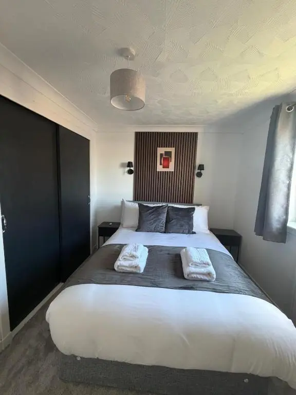a bedroom with a large bed with two towels on it at Nessy5 Apartment in Inverness