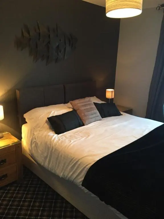 a bedroom with a large white bed with two pillows at Seafield Arms Hotel in Whitehills