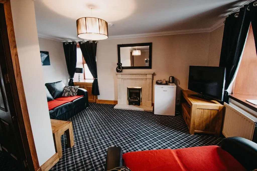 a living room with a couch and a fireplace at Seafield Arms Hotel in Whitehills