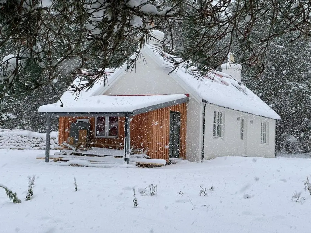 a small house with snow on the roof at Cosy Highland Cottage in the Woods on Royal Deeside in Coldstone