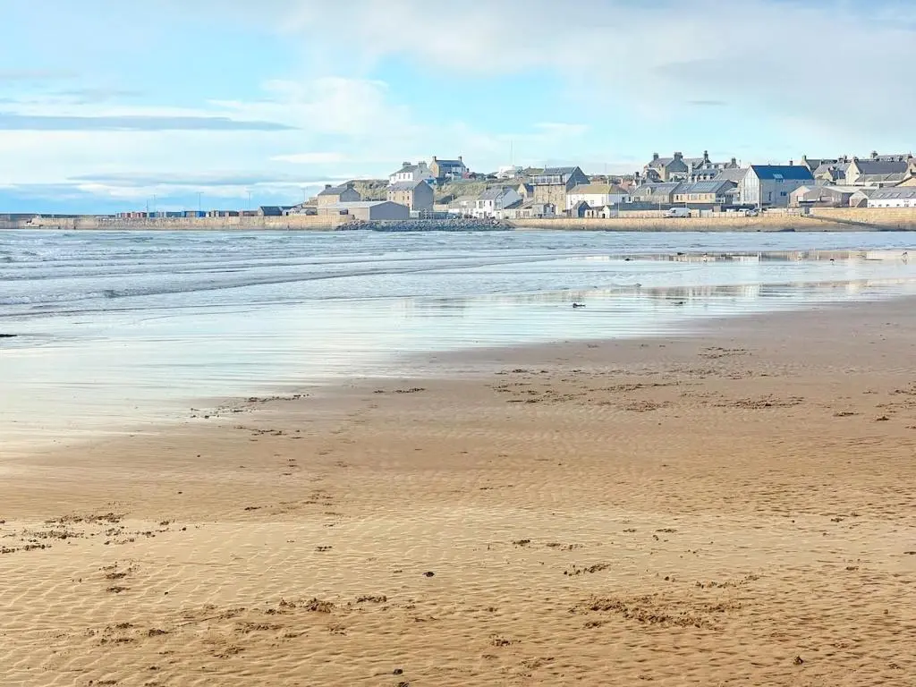 a view of a beach with houses in the background at The Beach Flat in Burghead