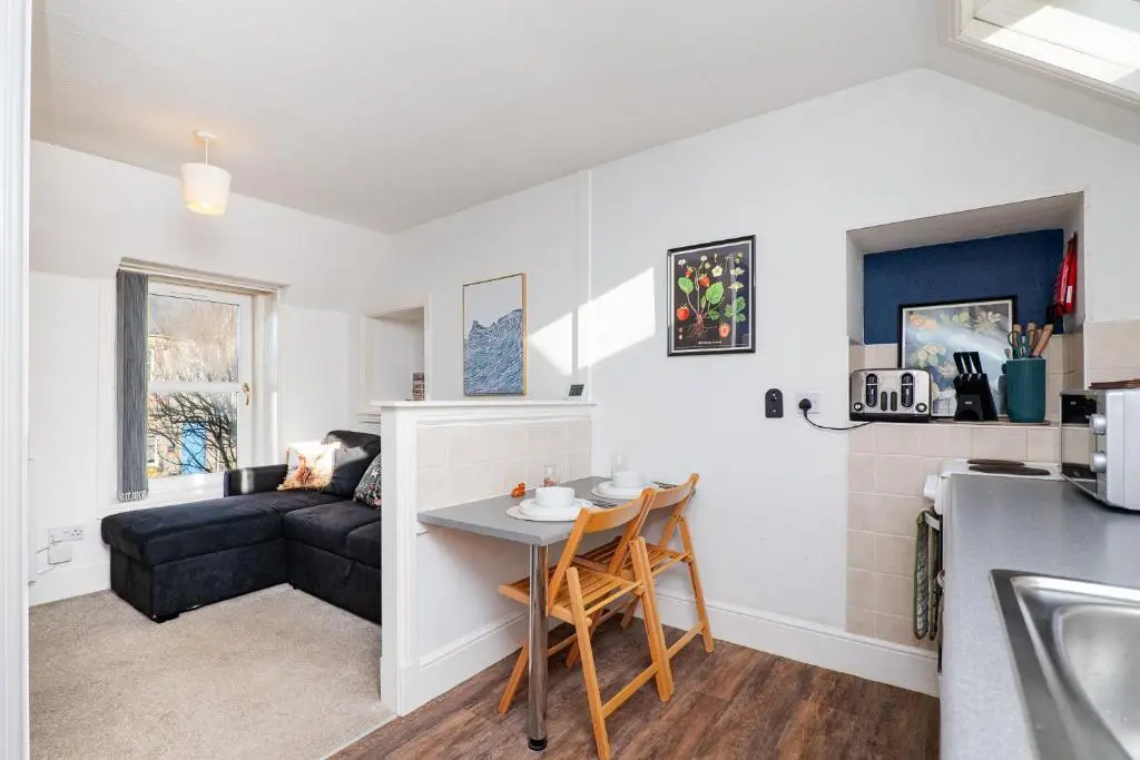 a kitchen and living room with a couch and a table at Charming 1-Bed Coastal Cottage by Holiday Homes in Portgordon